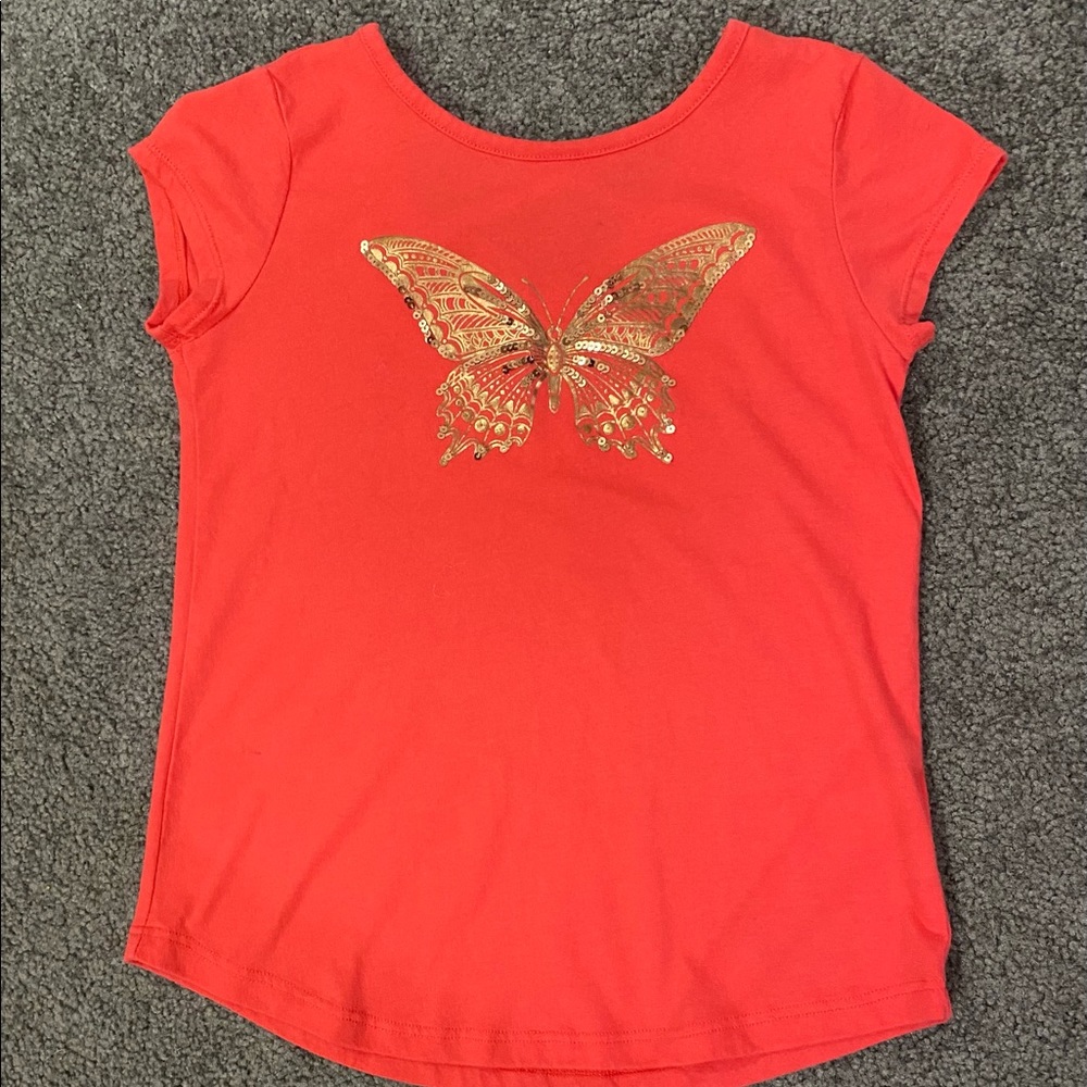 Kids orange Shirt with gold sequin butterfly on the front. Crisscross on back.